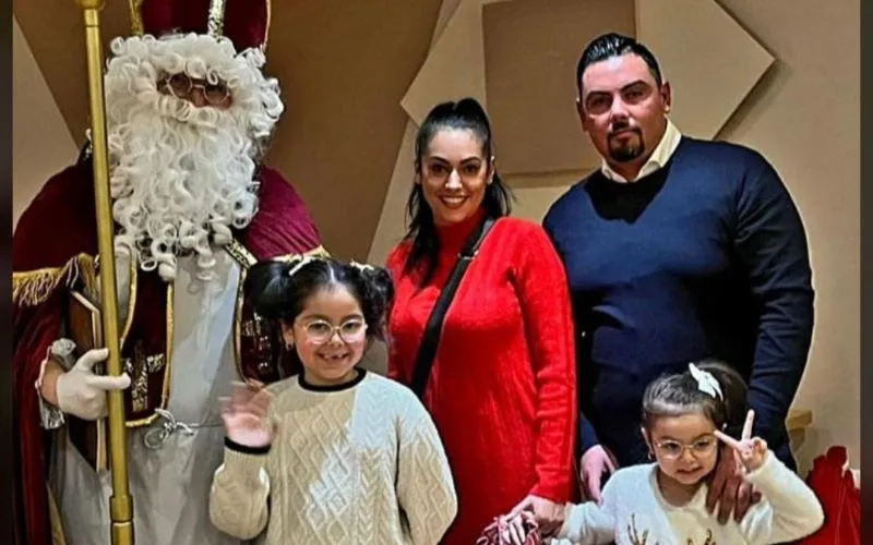 Nikolaus bei einer größeren Feier mit Geschenkübergabe Nikolaus steht mit einer Familie mit zwei Kindern und ihren Geschenken